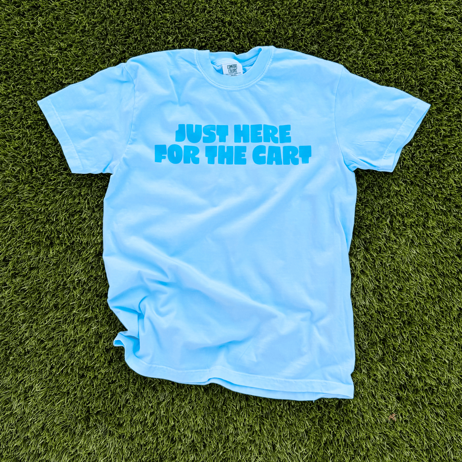 Light blue t-shirt with 'Just Here For The Car' text on grass