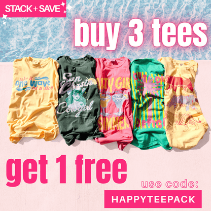 One Wave Tee in green, displayed among colorful tees on a sandy beach background.