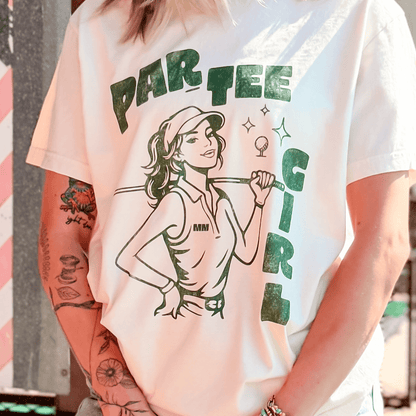 White t-shirt with a graphic design of a woman holding a golf club and text 'PAR TEE GIRL' on a blurred background.