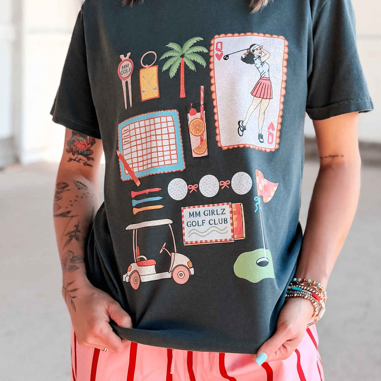 Person wearing a black t-shirt with colorful graphics and text.